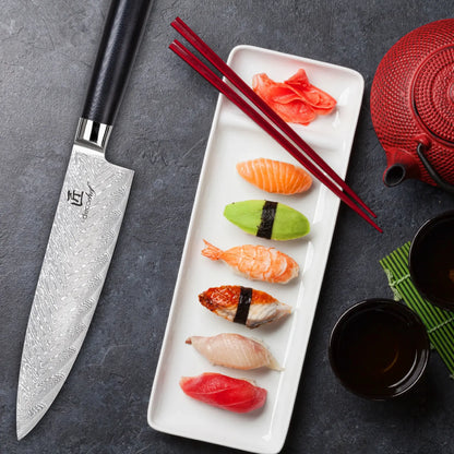 Chef knife on dark table with sushi platter